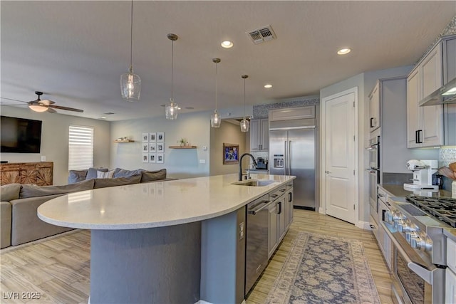 9964 Peaceful Peaks Ave, Las Vegas, NV 89166 - kitchen featuring stainless steel appliances, gray cabinets, a ceiling fan, open floor plan, and an island with sink