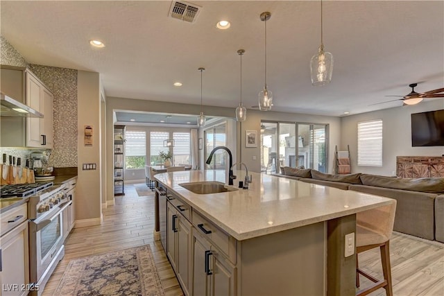 9964 Peaceful Peaks Ave, Las Vegas, NV 89166 - kitchen with high end stove, open floor plan, plenty of natural light, light wood finished floors, and recessed lighting