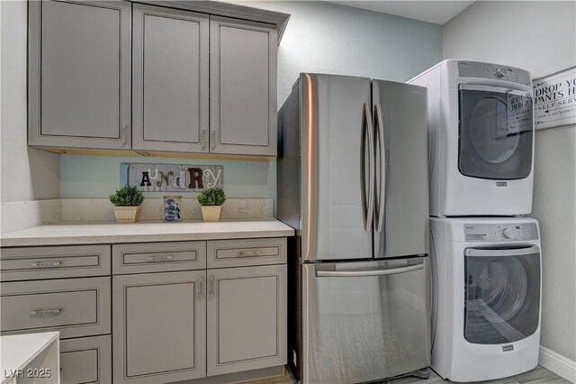 9964 Peaceful Peaks Ave, Las Vegas, NV 89166 - kitchen with freestanding refrigerator, estacked washer and dryer, light countertops, and gray cabinetry
