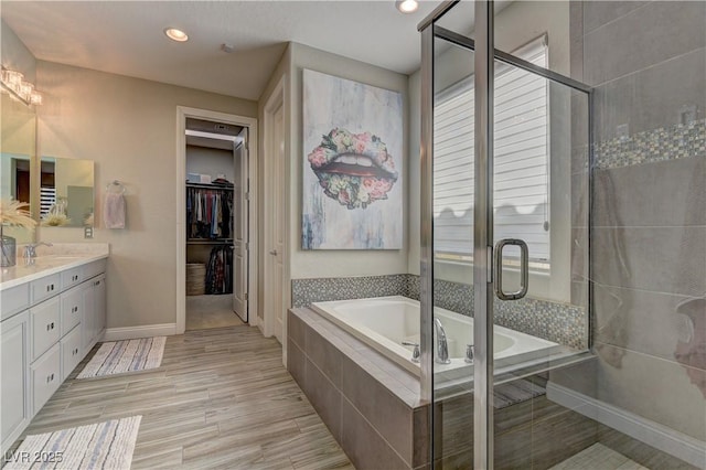 9964 Peaceful Peaks Ave, Las Vegas, NV 89166 - full bathroom with double vanity, a bath, a stall shower, a spacious closet, and recessed lighting