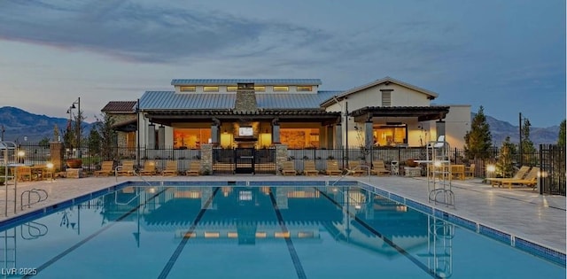 9964 Peaceful Peaks Ave, Las Vegas, NV 89166 - rear view of property featuring a mountain view, a community pool, and a metal roof