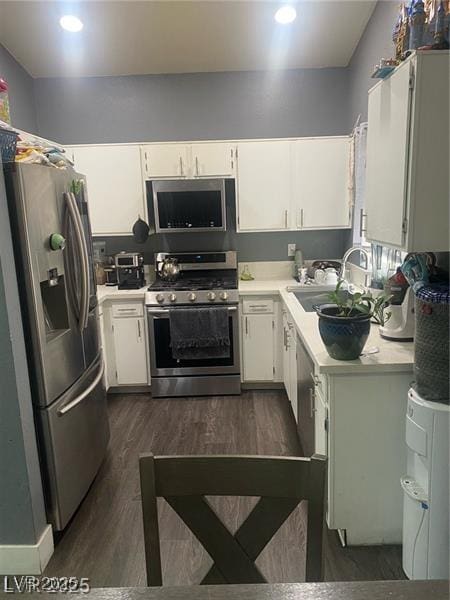 1841 Skywood Way, Las Vegas, NV 89142 - kitchen with stainless steel appliances, light countertops, white cabinets, dark wood-type flooring, and recessed lighting