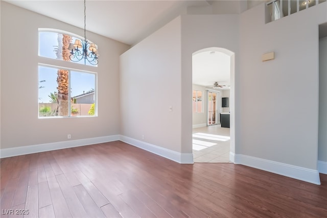 258 Horizon Pointe Cir, Henderson, NV 89012 - spare room featuring a high ceiling, arched walkways, wood finished floors, and a chandelier