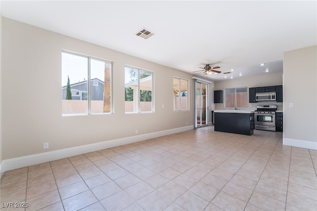 258 Horizon Pointe Cir, Henderson, NV 89012 - kitchen with stainless steel appliances, light countertops, light tile patterned flooring, a ceiling fan, and open floor plan