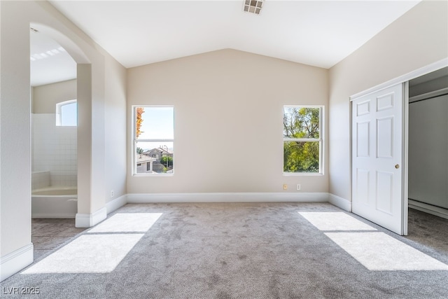 258 Horizon Pointe Cir, Henderson, NV 89012 - unfurnished bedroom with carpet, arched walkways, lofted ceiling, and connected bathroom