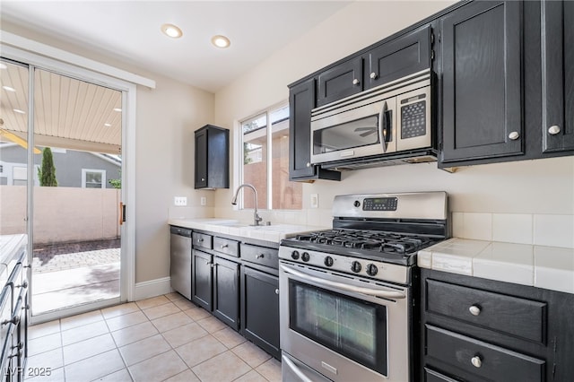 258 Horizon Pointe Cir, Henderson, NV 89012 - kitchen with stainless steel appliances, tile countertops, recessed lighting, light tile patterned floors, and dark cabinetry