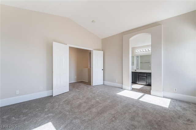 258 Horizon Pointe Cir, Henderson, NV 89012 - unfurnished bedroom featuring light colored carpet, lofted ceiling, connected bathroom, and arched walkways