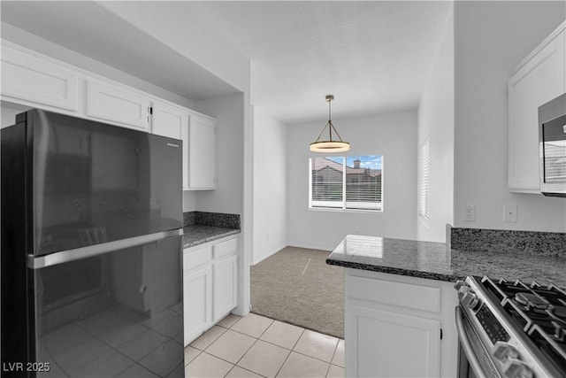 8501 W University Ave Unit 2053, Las Vegas, NV 89147 - kitchen with freestanding refrigerator, light carpet, white cabinets, gas stove, and dark stone countertops