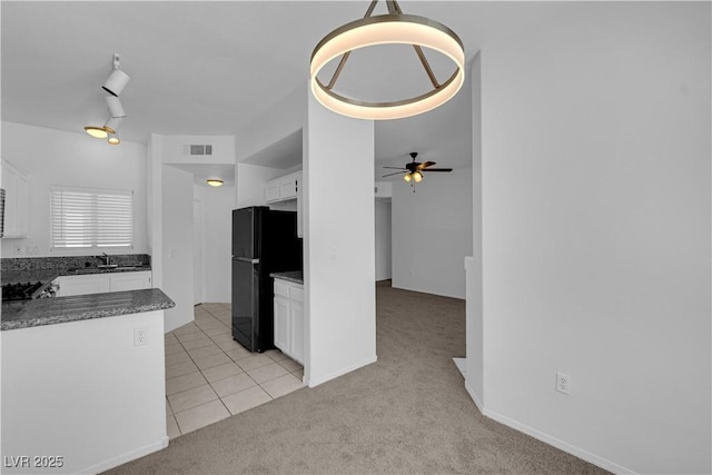 8501 W University Ave Unit 2053, Las Vegas, NV 89147 - kitchen featuring freestanding refrigerator, white cabinets, light carpet, ceiling fan, and light tile patterned floors
