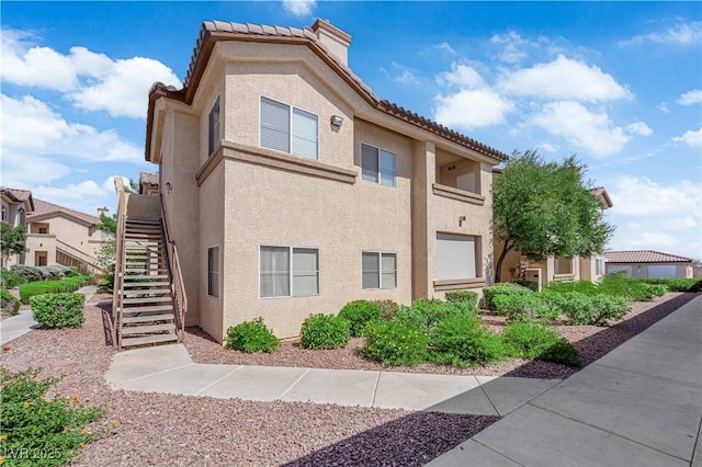 8501 W University Ave Unit 2053, Las Vegas, NV 89147 - view of side of property featuring stucco siding, stairway, and a tiled roof