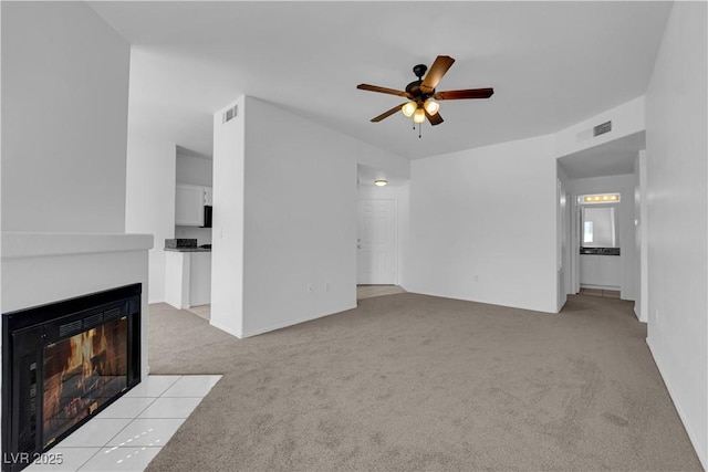 8501 W University Ave Unit 2053, Las Vegas, NV 89147 - unfurnished living room with light colored carpet, a ceiling fan, and a multi sided fireplace