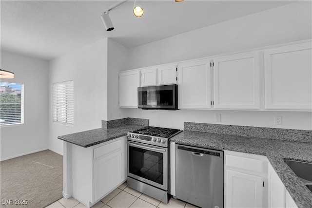 8501 W University Ave Unit 2053, Las Vegas, NV 89147 - kitchen with stainless steel appliances, a peninsula, white cabinetry, and dark stone counters