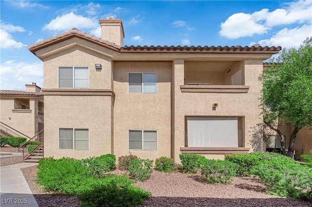 8501 W University Ave Unit 2053, Las Vegas, NV 89147 - view of home's exterior featuring a chimney, stucco siding, stairs, and a tile roof