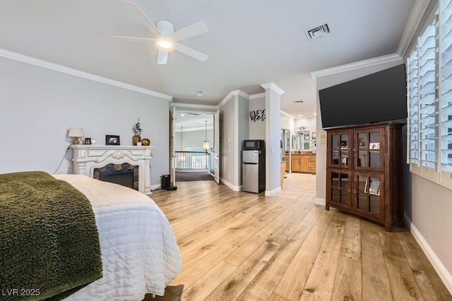2458 Tour Edition Dr, Henderson, NV 89074 - bedroom with freestanding refrigerator, ornamental molding, light wood-style floors, a fireplace, and connected bathroom
