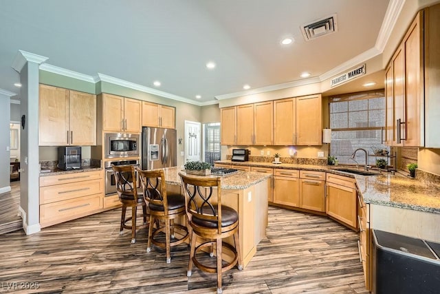 2458 Tour Edition Dr, Henderson, NV 89074 - kitchen with stainless steel appliances, light brown cabinets, crown molding, dark wood-type flooring, and recessed lighting