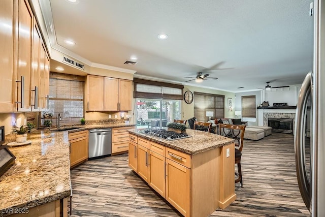 2458 Tour Edition Dr, Henderson, NV 89074 - kitchen with appliances with stainless steel finishes, light brown cabinets, ornamental molding, dark wood finished floors, and recessed lighting
