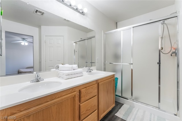 8179 Palace Monaco Ave, Las Vegas, NV 89117 - full bathroom featuring double vanity, a shower stall, ceiling fan, and wood finished floors