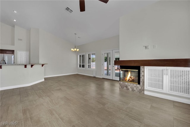 4423 Sophia Way N, Las Vegas, NV 89032 - unfurnished living room featuring a ceiling fan, a chandelier, a multi sided fireplace, high vaulted ceiling, and french doors
