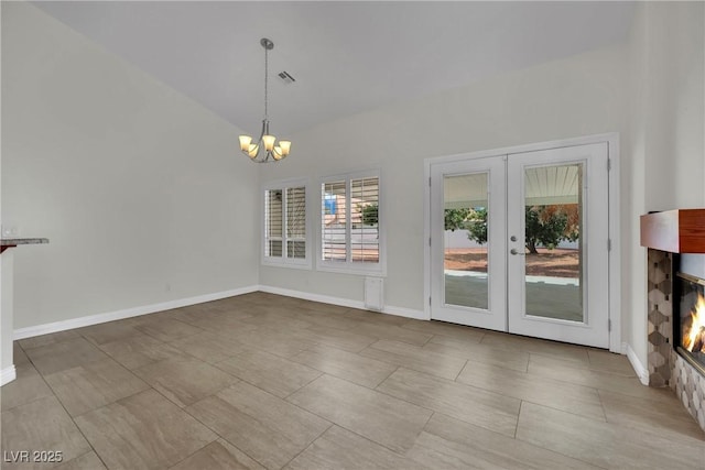 4423 Sophia Way N, Las Vegas, NV 89032 - unfurnished dining area featuring a chandelier, french doors, lofted ceiling, and a glass covered fireplace