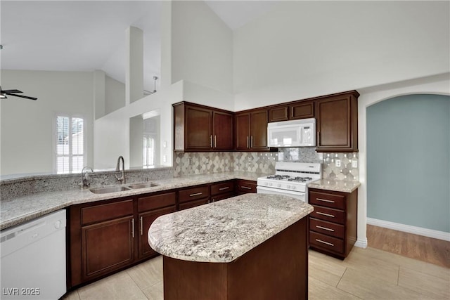 4423 Sophia Way N, Las Vegas, NV 89032 - kitchen featuring white appliances, high vaulted ceiling, backsplash, a kitchen island, and light stone countertops