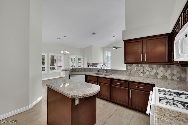 4423 Sophia Way N, Las Vegas, NV 89032 - kitchen with decorative backsplash, white appliances, a peninsula, dark brown cabinetry, and high vaulted ceiling