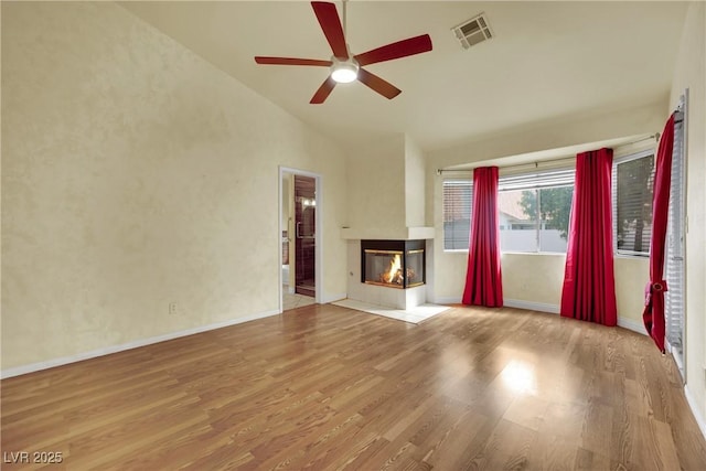 4423 Sophia Way N, Las Vegas, NV 89032 - unfurnished living room with a multi sided fireplace, a ceiling fan, lofted ceiling, and wood finished floors