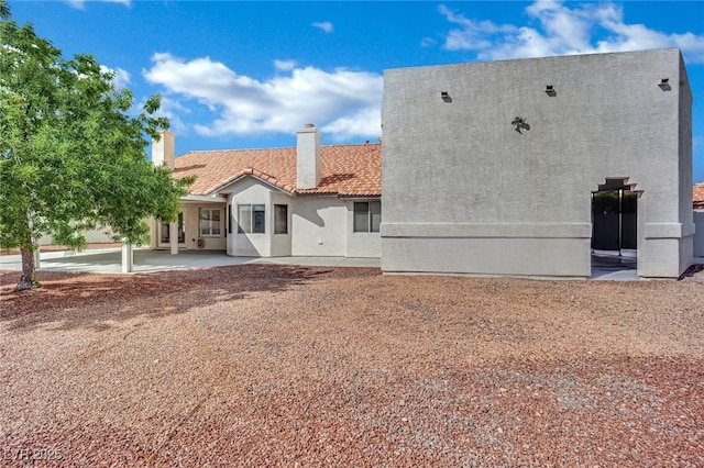 4423 Sophia Way N, Las Vegas, NV 89032 - back of house with a tiled roof, a patio area, stucco siding, and a chimney