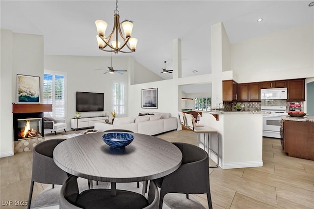 4423 Sophia Way N, Las Vegas, NV 89032 - dining area featuring a ceiling fan, a chandelier, a multi sided fireplace, and high vaulted ceiling