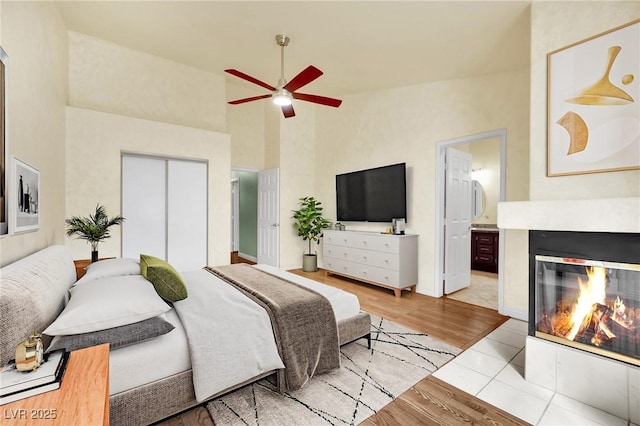 4423 Sophia Way N, Las Vegas, NV 89032 - bedroom with wood finished floors, a closet, high vaulted ceiling, a fireplace with flush hearth, and ensuite bathroom