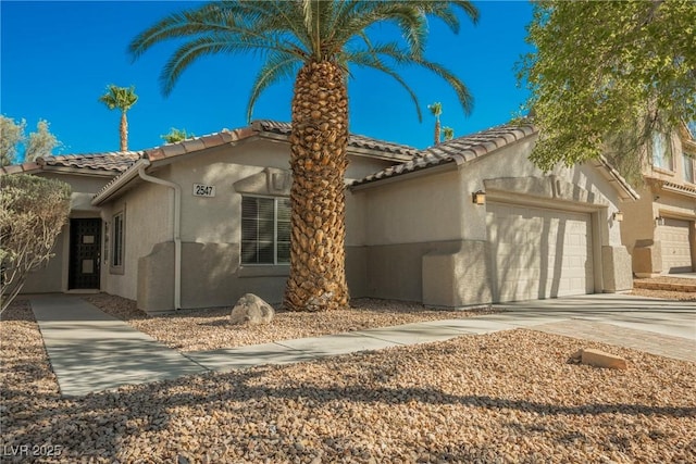 2547 Sundew Ave, Henderson, NV 89052 - mediterranean / spanish home featuring a tiled roof, a garage, stucco siding, and concrete driveway