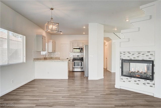 9520 Silver Frost St, Las Vegas, NV 89123 - kitchen with appliances with stainless steel finishes, open floor plan, wood finished floors, tasteful backsplash, and recessed lighting