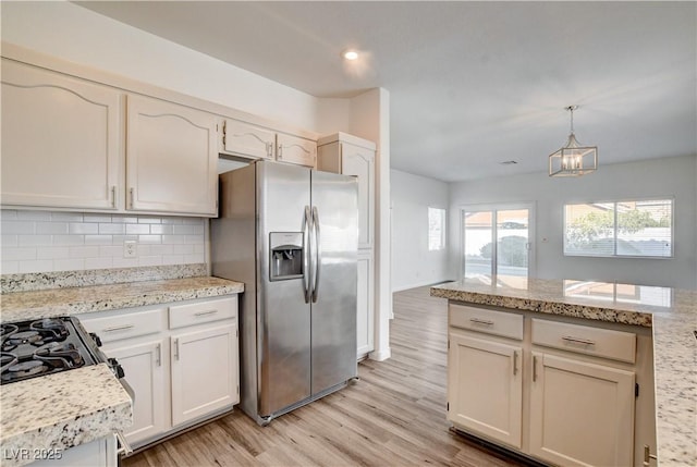 9520 Silver Frost St, Las Vegas, NV 89123 - kitchen featuring stainless steel refrigerator with ice dispenser, light wood-style flooring, tasteful backsplash, a chandelier, and pendant lighting