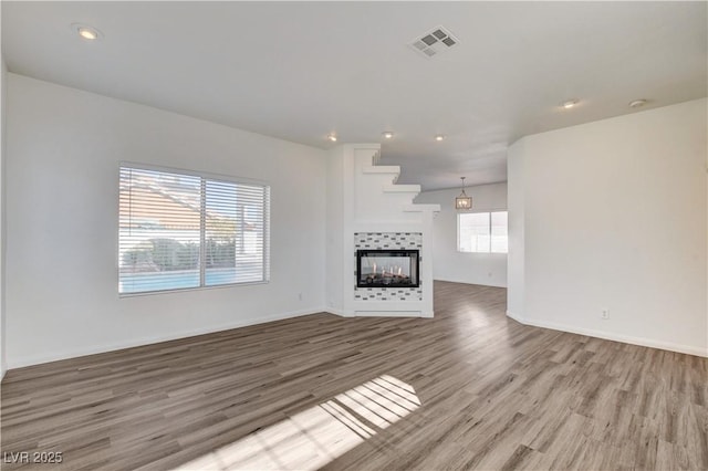 9520 Silver Frost St, Las Vegas, NV 89123 - unfurnished living room featuring wood finished floors, a multi sided fireplace, and recessed lighting