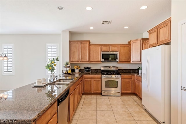 2425 Sky Watcher St, Henderson, NV 89044 - kitchen featuring appliances with stainless steel finishes, a peninsula, dark stone countertops, recessed lighting, and light tile patterned flooring