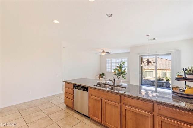 2425 Sky Watcher St, Henderson, NV 89044 - kitchen with stainless steel dishwasher, dark stone countertops, brown cabinets, pendant lighting, and light tile patterned floors
