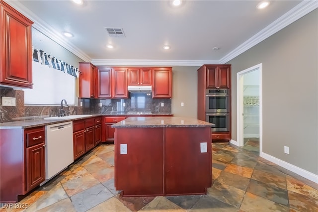 1152 Highbury Grove St, Henderson, NV 89002 - kitchen featuring appliances with stainless steel finishes, reddish brown cabinets, under cabinet range hood, a kitchen island, and ornamental molding