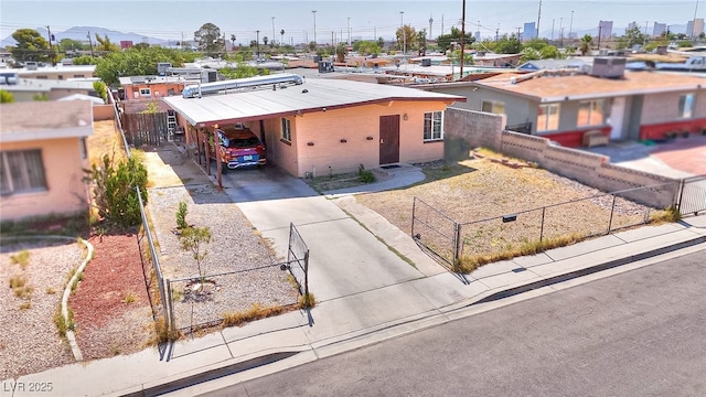 304 N Minnesota St, Las Vegas, NV 89107 - view of front facade featuring concrete driveway, a fenced front yard, and an attached carport