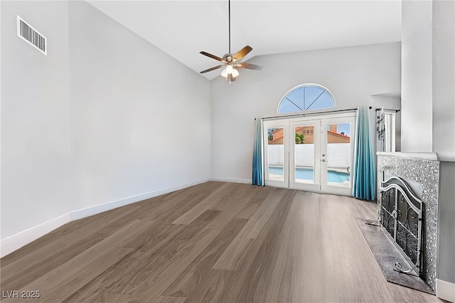 9405 Crosspointe Ave, Las Vegas, NV 89117 - unfurnished living room with a ceiling fan, wood finished floors, french doors, high vaulted ceiling, and a tile fireplace