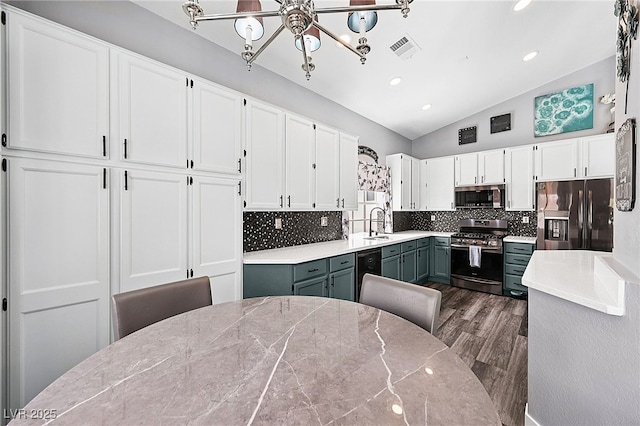 9405 Crosspointe Ave, Las Vegas, NV 89117 - kitchen with stainless steel appliances, a chandelier, vaulted ceiling, white cabinets, and dark wood-style floors