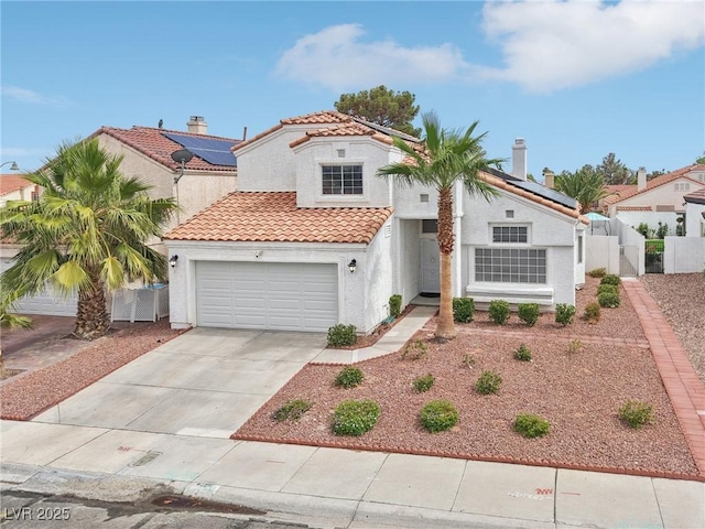 9405 Crosspointe Ave, Las Vegas, NV 89117 - mediterranean / spanish house with stucco siding, a gate, roof mounted solar panels, concrete driveway, and a tiled roof