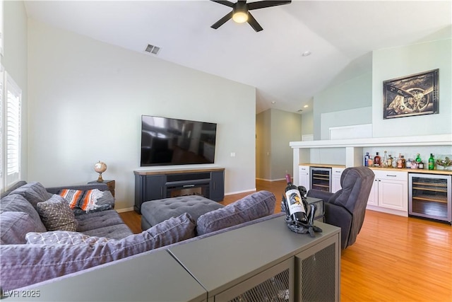 625 Bright Lights Ave, North Las Vegas, NV 89031 - living room featuring beverage cooler, a dry bar, vaulted ceiling, and light wood-type flooring