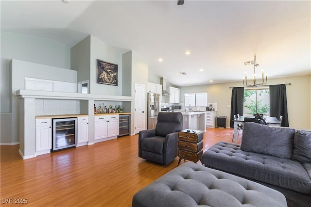 625 Bright Lights Ave, North Las Vegas, NV 89031 - living area with beverage cooler, a bar, light wood-style floors, lofted ceiling, and recessed lighting