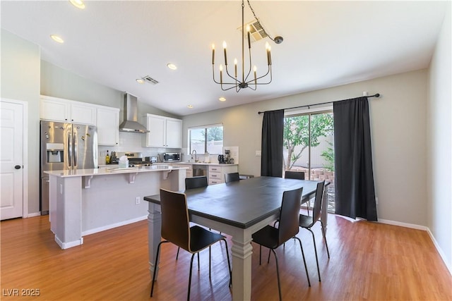 625 Bright Lights Ave, North Las Vegas, NV 89031 - dining space featuring a chandelier, light wood-style flooring, lofted ceiling, and recessed lighting