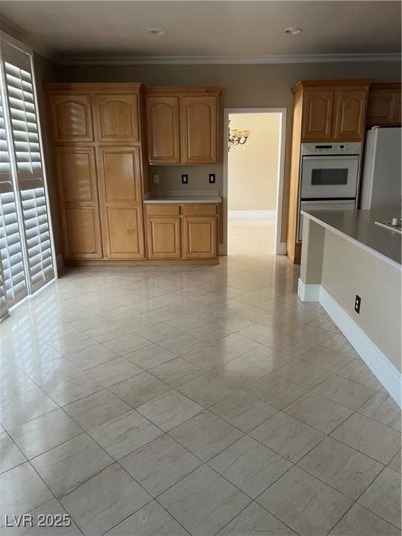 11004 Mount Royal Ave, Las Vegas, NV 89144 - kitchen with freestanding refrigerator, crown molding, light countertops, light tile patterned floors, and white double oven