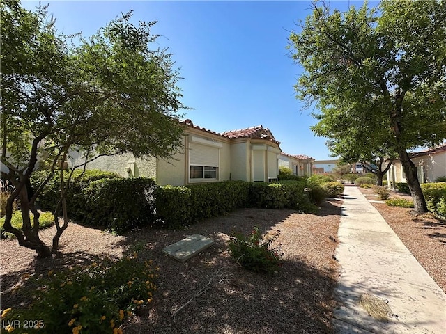 5449 Bugle Way Unit 105, Las Vegas, NV 89108 - view of home's exterior featuring stucco siding and a tile roof
