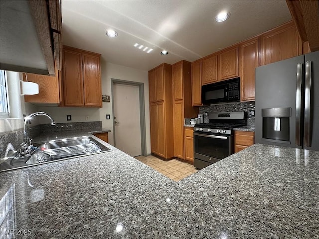 5449 Bugle Way Unit 105, Las Vegas, NV 89108 - kitchen with appliances with stainless steel finishes, brown cabinetry, dark stone counters, and recessed lighting