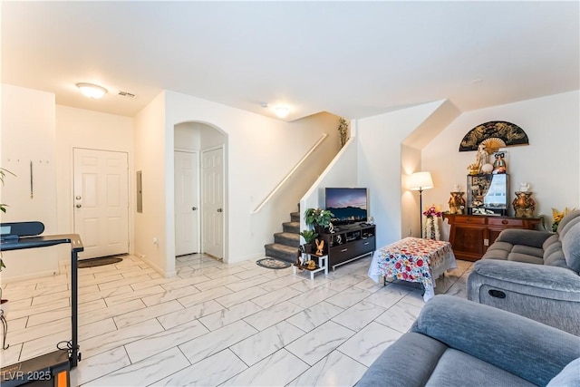 6312 Beige Bluff St Unit 102, North Las Vegas, NV 89081 - living room featuring arched walkways, light marble finish floors, stairway, and electric panel
