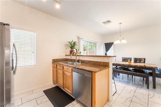 6312 Beige Bluff St Unit 102, North Las Vegas, NV 89081 - kitchen featuring stainless steel appliances, light marble finish flooring, a chandelier, a peninsula, and dark stone counters