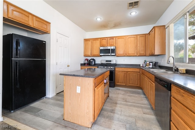 4062 W El Campo Grande Ave, North Las Vegas, NV 89031 - kitchen featuring appliances with stainless steel finishes, light wood-type flooring, dark countertops, a center island, and recessed lighting