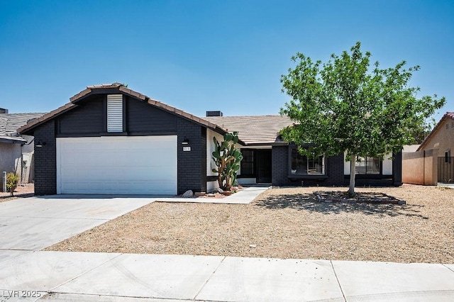 4319 Basil Leaf Ave, North Las Vegas, NV 89031 - view of front facade with a tile roof, an attached garage, concrete driveway, and brick siding